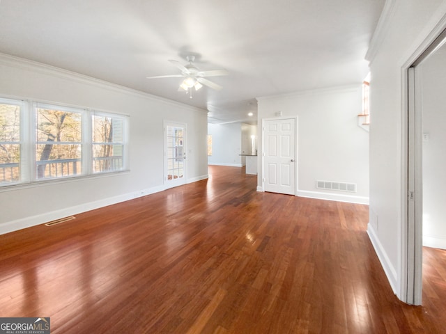 spare room featuring crown molding, dark hardwood / wood-style flooring, and a healthy amount of sunlight