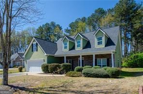 new england style home with a garage and a porch