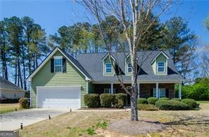 cape cod home with a garage and a porch