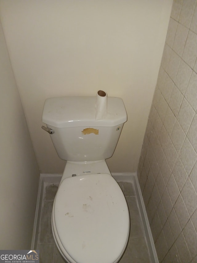 interior space featuring tile flooring and toilet