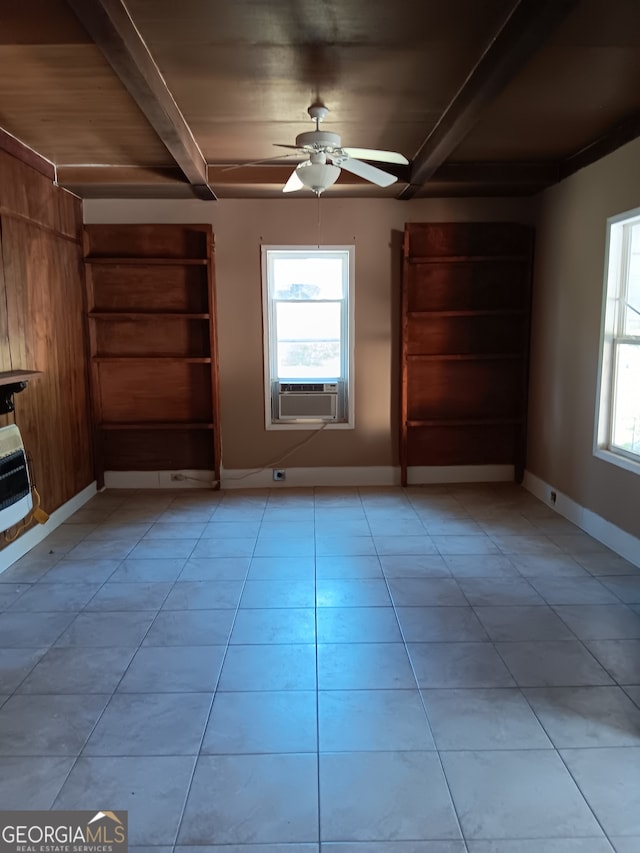 tiled empty room with beam ceiling, ceiling fan, and a healthy amount of sunlight