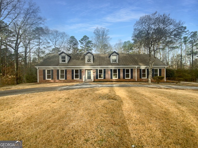 cape cod house featuring a front yard