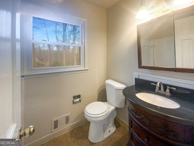 bathroom with tile floors, toilet, and vanity