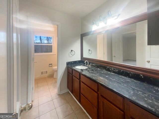 bathroom featuring toilet, large vanity, and tile floors