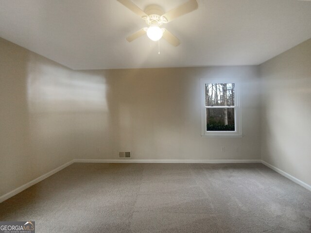 carpeted spare room with ceiling fan