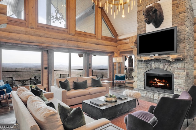 living room featuring high vaulted ceiling, a notable chandelier, a fireplace, and dark wood-type flooring