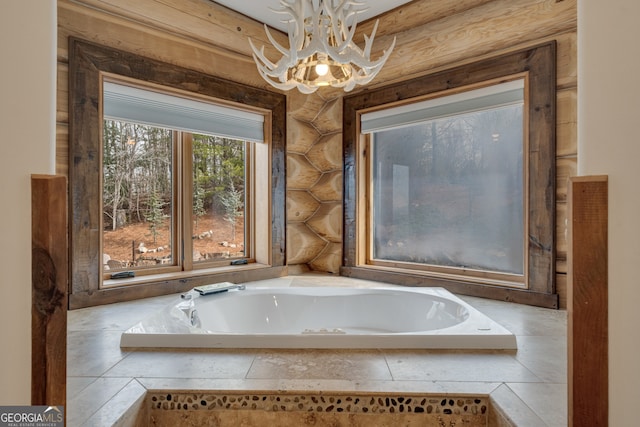 bathroom featuring rustic walls, tiled bath, and a notable chandelier