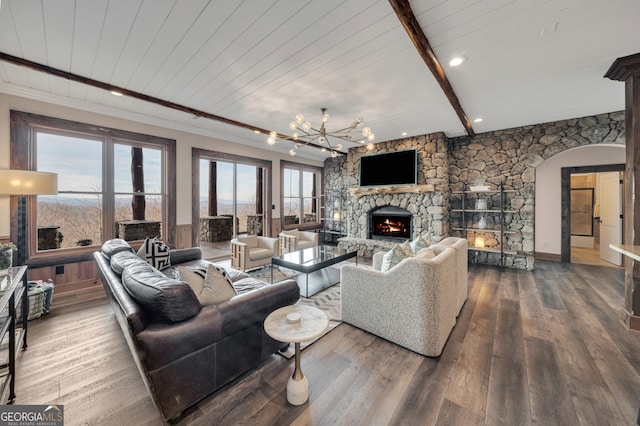 living room with a fireplace, beam ceiling, dark hardwood / wood-style flooring, and a chandelier