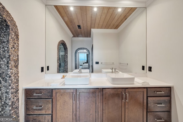 bathroom featuring wood ceiling, crown molding, and double vanity