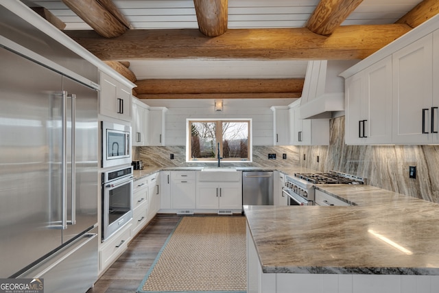 kitchen featuring built in appliances, tasteful backsplash, dark wood-type flooring, and beamed ceiling