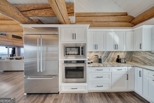 kitchen featuring backsplash, built in appliances, light hardwood / wood-style floors, and white cabinetry