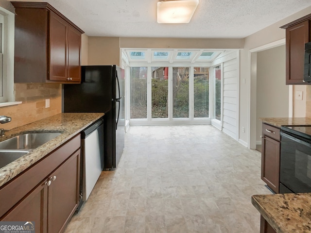 kitchen featuring light tile floors, dishwasher, backsplash, light stone countertops, and a textured ceiling