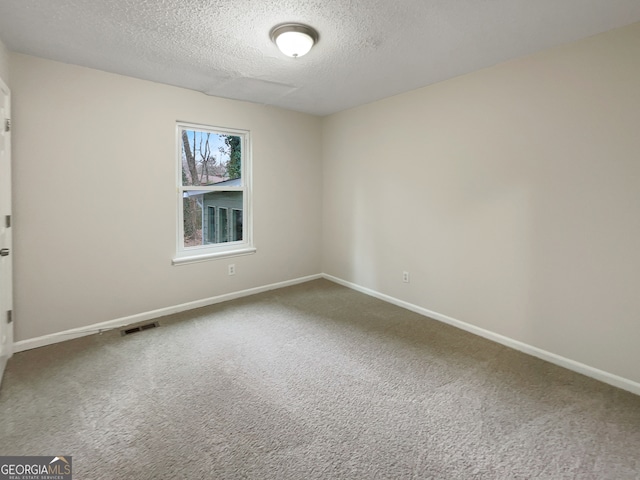 carpeted spare room featuring a textured ceiling