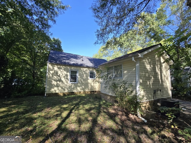 exterior space featuring cooling unit and a lawn