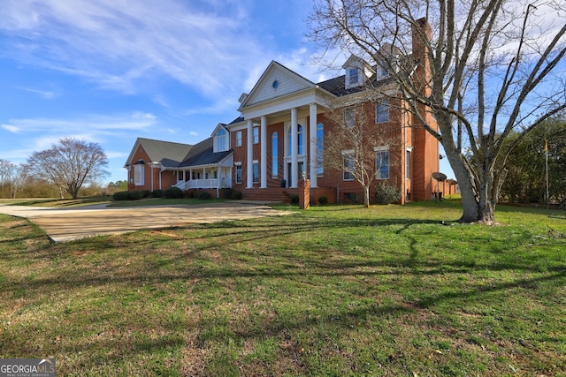 greek revival house featuring a front yard and covered porch