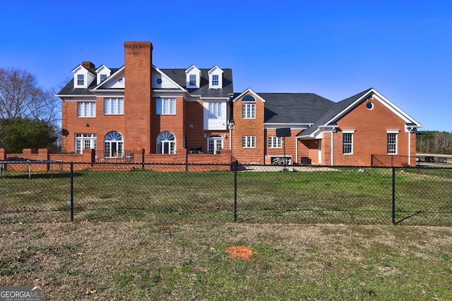 rear view of property featuring a lawn