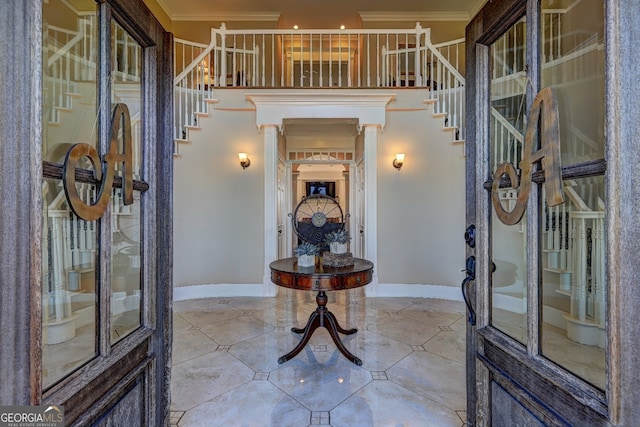 foyer entrance with light tile flooring and ornamental molding