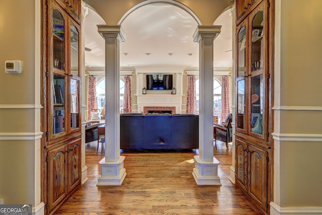 entryway with wood-type flooring and ornate columns