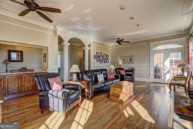 living room with ornate columns, french doors, crown molding, light wood-type flooring, and ceiling fan