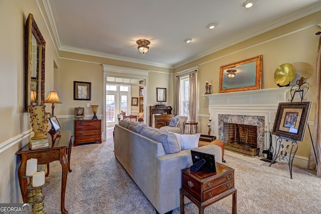 carpeted living room with french doors, crown molding, a premium fireplace, and plenty of natural light