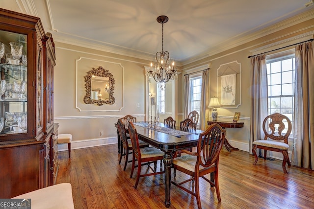 dining room featuring dark hardwood / wood-style flooring, an inviting chandelier, and ornamental molding