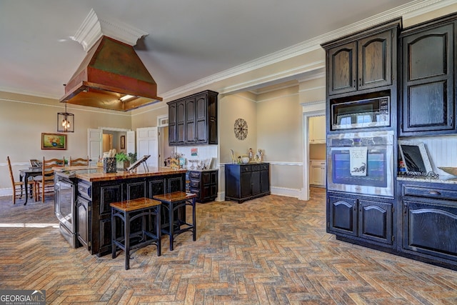 kitchen featuring stainless steel appliances, a kitchen bar, parquet floors, dark brown cabinets, and hanging light fixtures