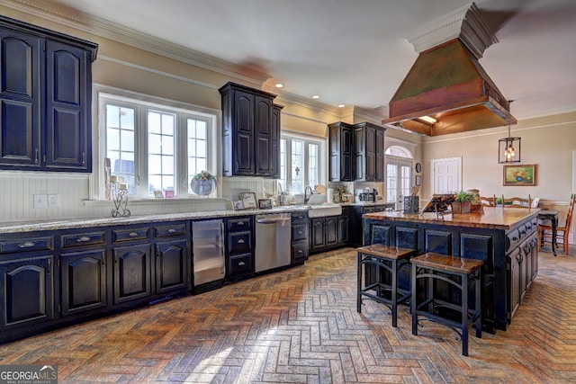 kitchen with a center island, stainless steel dishwasher, light stone counters, a breakfast bar area, and pendant lighting