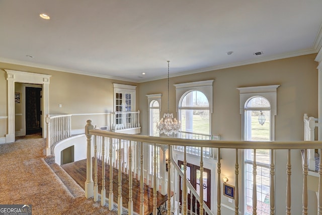 corridor featuring an inviting chandelier, carpet flooring, and ornamental molding