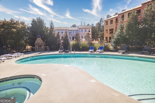 view of swimming pool featuring a patio area and a hot tub