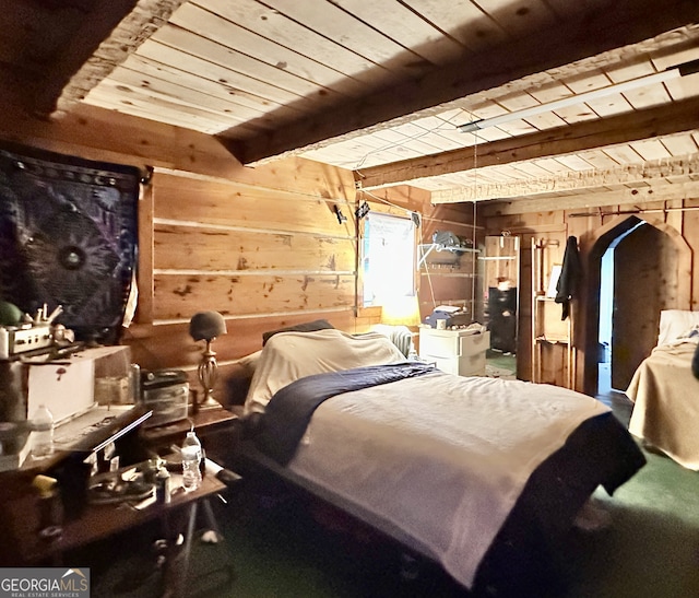 bedroom with wood ceiling, wood walls, and beamed ceiling