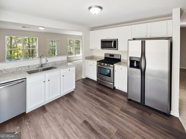 338 Hunterian Pl, Newnan, GA 30265 - kitchen with light stone counters, a sink, white cabinets, appliances with stainless steel finishes, and visible vents