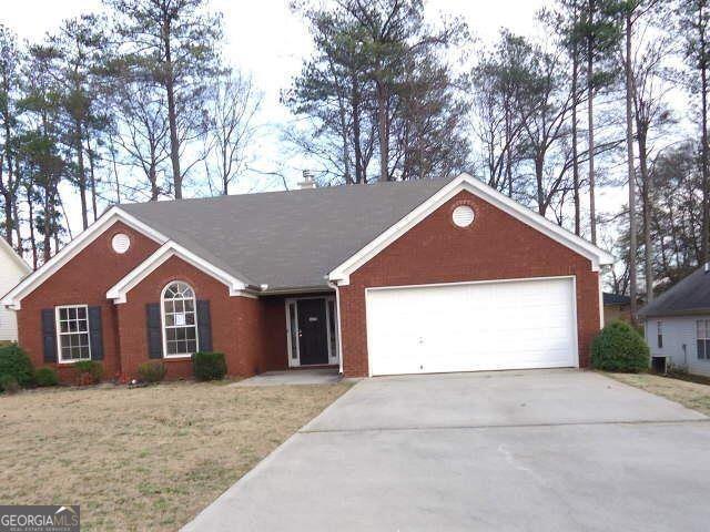 ranch-style house with a front yard and a garage