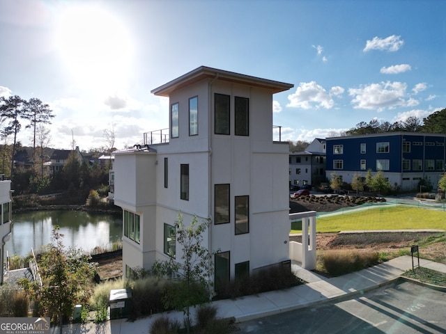 view of property exterior with a yard and a water view