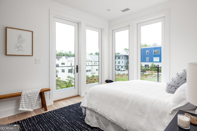 bedroom with light hardwood / wood-style floors and access to outside