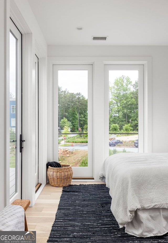 bedroom with light hardwood / wood-style floors and multiple windows