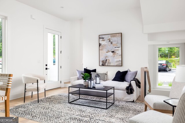 living room featuring vaulted ceiling and light hardwood / wood-style floors