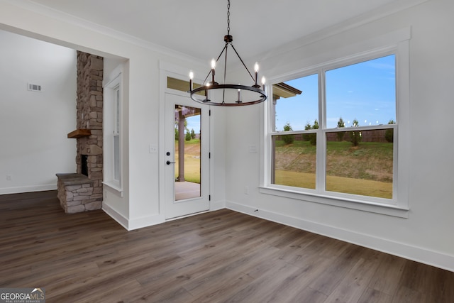 unfurnished dining area with a fireplace, a wealth of natural light, dark hardwood / wood-style floors, and crown molding