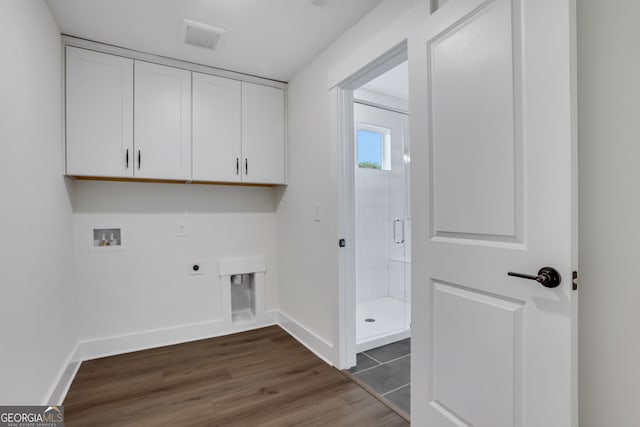 clothes washing area featuring cabinets, dark hardwood / wood-style floors, hookup for a washing machine, and electric dryer hookup