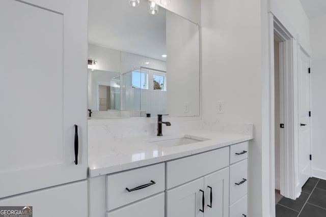 bathroom with vanity, a shower with shower door, and tile patterned floors