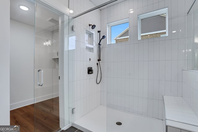 bathroom featuring hardwood / wood-style floors and walk in shower