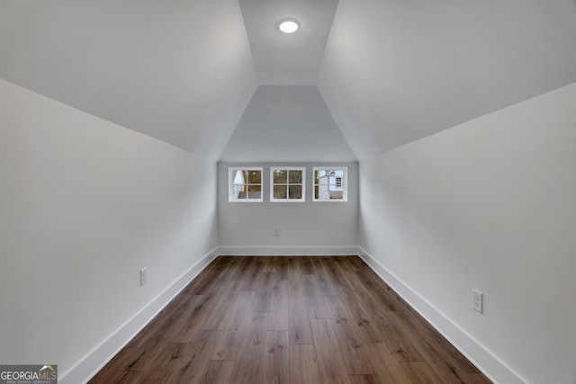 additional living space with wood-type flooring and vaulted ceiling