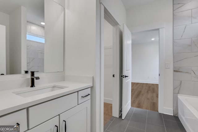 bathroom featuring a bathtub, vanity, and tile patterned floors