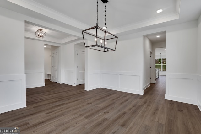 unfurnished dining area featuring ornamental molding, dark hardwood / wood-style floors, and a raised ceiling