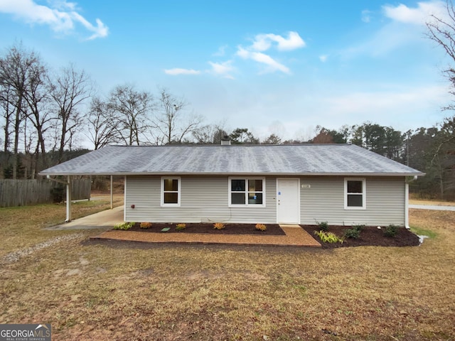 ranch-style house with a chimney, a front lawn, and a carport