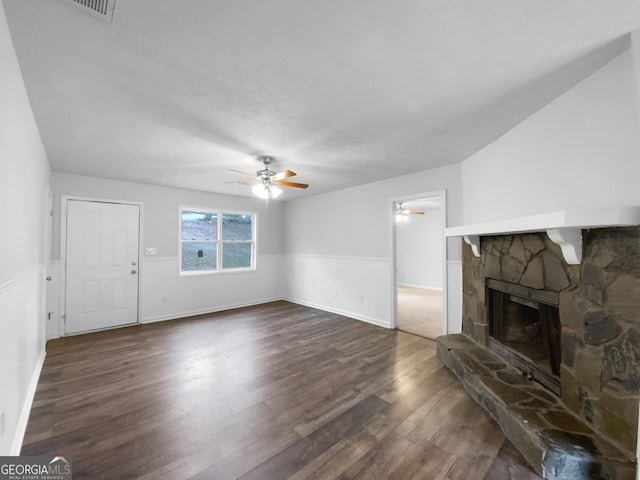 living room with dark wood-type flooring, a fireplace, a ceiling fan, and baseboards