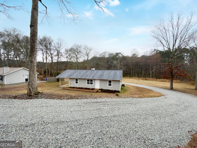 view of front of home featuring a chimney and gravel driveway