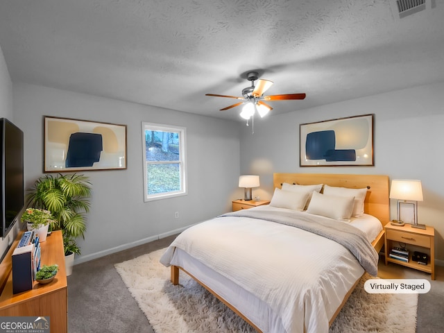 bedroom with visible vents, dark carpet, a ceiling fan, a textured ceiling, and baseboards