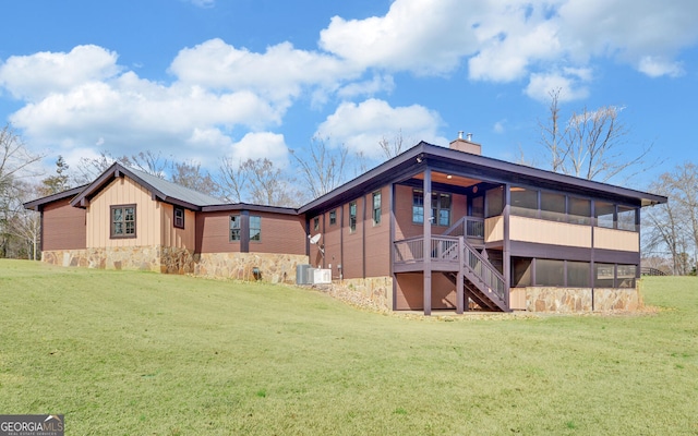 back of house featuring a lawn and a sunroom