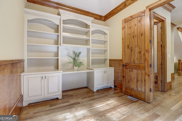 interior space featuring light hardwood / wood-style floors and crown molding