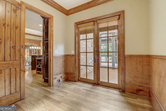 doorway with light wood-type flooring, ornamental molding, and french doors